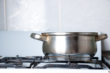 An old dirty pan with stains of fat is on the stove.
