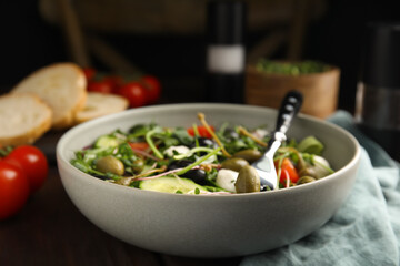 Fresh salad with vegetables, capers and mozzarella in bowl, closeup