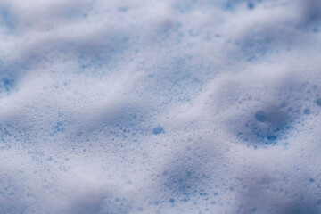 White foam on light blue background, closeup