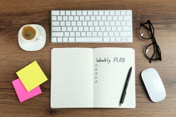 Flat lay composition of notebook with weekly plan on wooden table