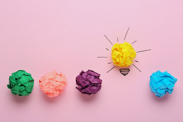 Composition with crumpled paper ball as lamp bulb on pink background, flat lay. Idea concept