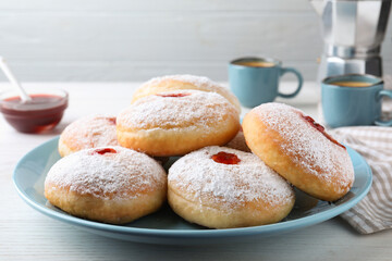 Delicious donuts with jam and powdered sugar on white table, closeup