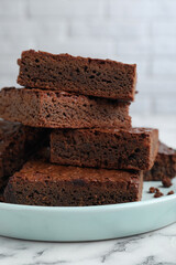 Delicious chocolate brownies on white marble table, closeup