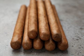 Many expensive cigars on grey table, closeup