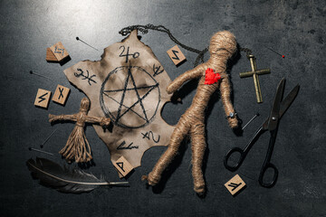 Voodoo dolls and ceremonial items on grey table, flat lay