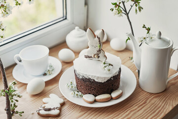 Celebration and holiday. Easter cake with gingerbread, homemade cake, eggs. Easter bunny and flowering branches postcard