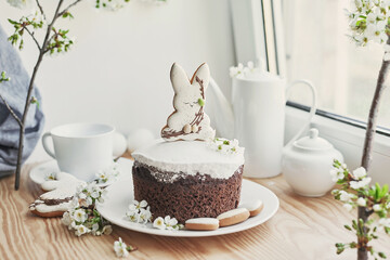 Celebration and holiday. Easter cake with gingerbread, homemade cake, eggs. Easter bunny and flowering branches postcard