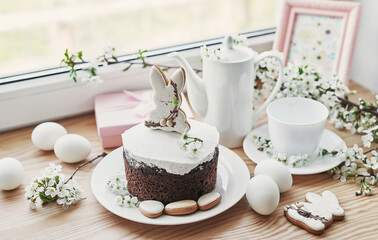 Celebration and holiday. Easter cake with gingerbread, homemade cake, eggs. Easter bunny and flowering branches postcard