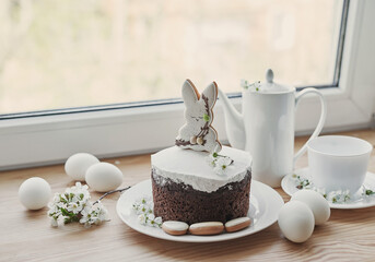 Celebration and holiday. Easter cake with gingerbread, homemade cake, eggs. Easter bunny and flowering branches postcard