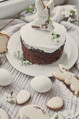 Celebration and holiday. Easter cake with gingerbread, homemade cake, eggs. Easter bunny and flowering branches postcard