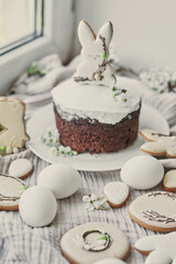 Celebration and holiday. Easter cake with gingerbread, homemade cake, eggs. Easter bunny and flowering branches postcard