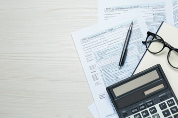 Calculator, glasses, documents and stationery on white wooden table, flat lay with space for text. Tax accounting