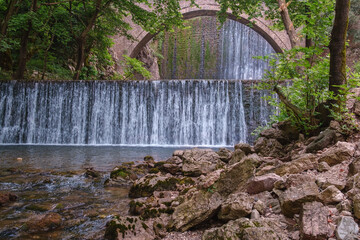 Paleokarya, old, stone, arched bridge, between two waterfalls. Trikala prefecture, Thessaly, Greece