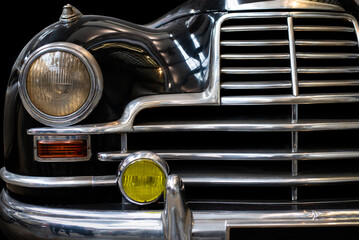 Detail of the front headlight of an old black car