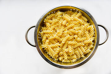 Boiled vermicelli noodles horns in a colander