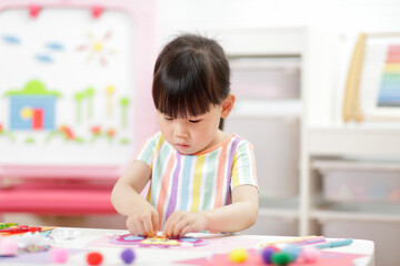 young girl making paper craft for homeschooling