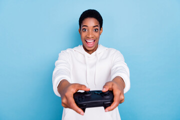 Photo of beautiful attractive unisex lady dressed white hoodie enjoying playstation isolated blue color background