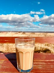 Kaffeeglas in freier Natur auf roter Bank