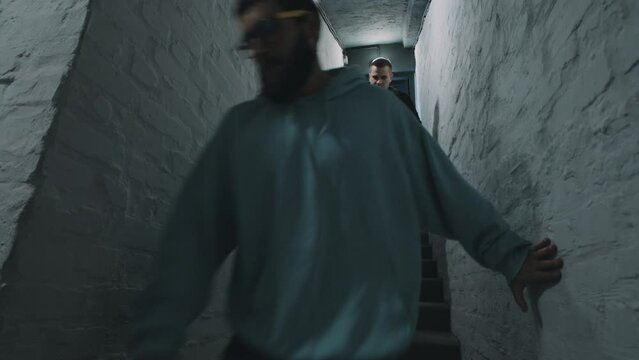 A team of programmers during the war descending the stairs to the basement to hide from the bombing