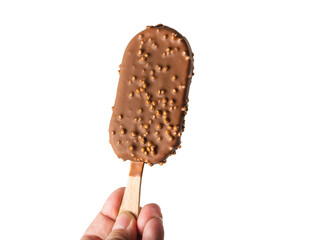 A woman holds an ice cream with chocolate and nuts by the stick. A cold chocolate popsicle is held by a woman's hand. Isolated
