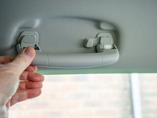 hinged spring loaded saftey grab rail handle fitted to a n auto car door head lining