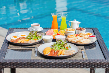 American breakfast near swimming pool, exotic food at luxury hotel resort spa at hot sunny day....