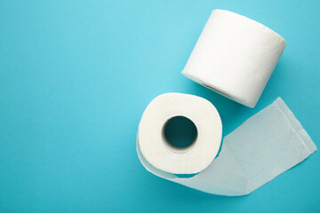 Roll of toilet paper on blue background. Space for text