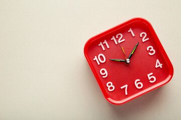Red wall clock on grey background. Space for text
