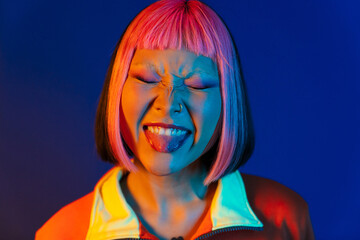 Asian girl with pink hair and piercing showing her tongue