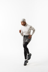 Young sportsman wearing bandana doing exercise while working out