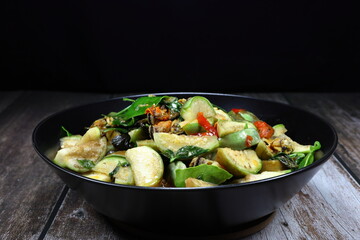 Traditional fried and stirred spicy fresh Thai eggplant mixed with mussel meat serving on the plate. 