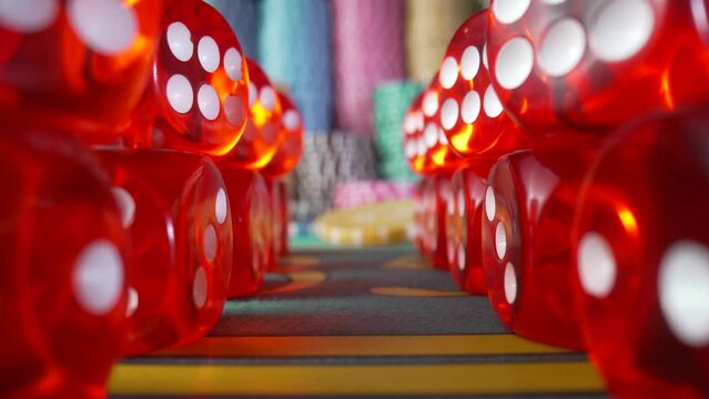 Camera moves along the rows of red dice and zooms in on the casino chips. Game table for gambling, poker, blackjack in the casino. Concept of betting, entertainment, leisure. Online casino. Close up.