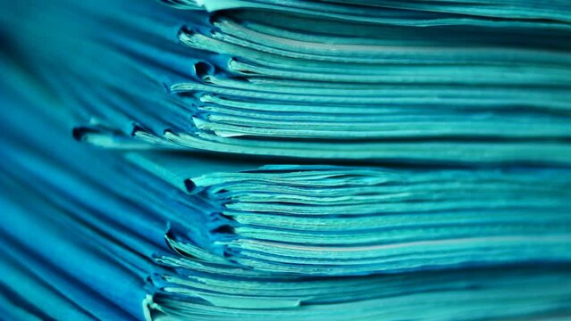 Close up of files, papers, newspapers in a stack on the desk.