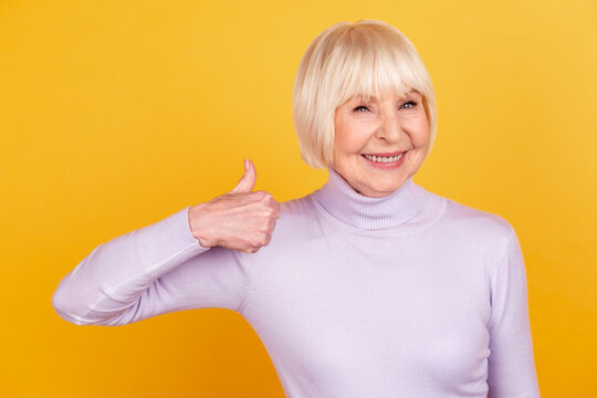 Photo of mature woman show thumb-up advert promo select great ideal isolated over yellow color background