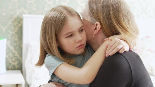 mom hugs and soothes her sad daughter. childish whims and tears. psychological trauma and fears. the relationship between parents and child.