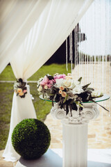 Festive wedding arch for the newlyweds, decorated with a bouquet of white, yellow and pink flowers...