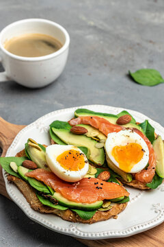 Ketogenic diet breakfast. Toast salmon, avocado, cheese, egg, spinach, nuts and coffee, Healthy fats, clean eating for weight loss. vertical image. top view. place for text