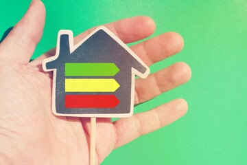 Hand holding a house with the energetic classification arrows.