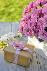 Geschenk mit Deko und Blumen in weißer Holzkiste