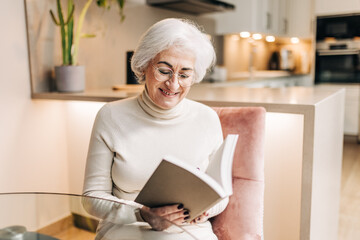 Retired senior woman reading a book at home