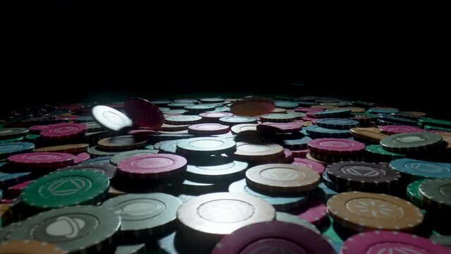 Casino chips on a gaming table in a casino on a black background. Chips falling on a pile close up in slow motion. The concept of gambling and entertainment. Win, poker betting, roulette, blackjack.
