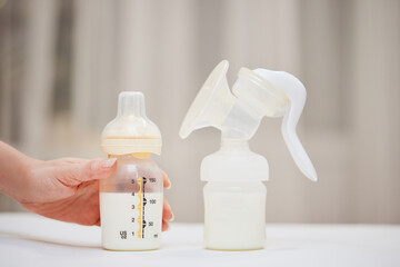 Breast pump and bottle with milk for baby