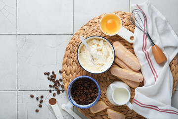 Tiramisu dessert. Ingredients for making dessert tiramisu. Cooking Italian food dessert Tiramisu with all  necessary ingredients cocoa, coffee, mascarpone cheese on grey stone background. Copy space