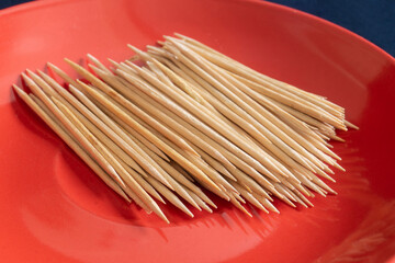 Wooden toothpicks on a red background.