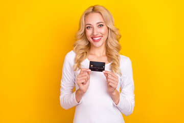 Photo of sweet adorable lady dressed white shirt rising credit card isolated yellow color background