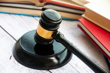 Lawyer gavel on wooden table with wooden desk and books background. Copy space and law concept