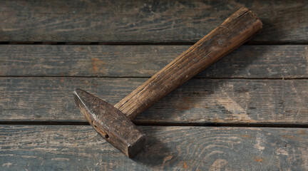 Old hammer on a wooden background