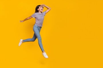 Fototapeta na wymiar Full body profile side photo of young excited girl watch empty space go walk isolated over yellow color background