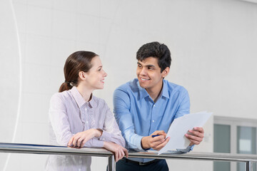 young woman and colleague discuss document