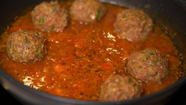 Cooking meatballs with tomato sauce in a pan . High quality 4k footage